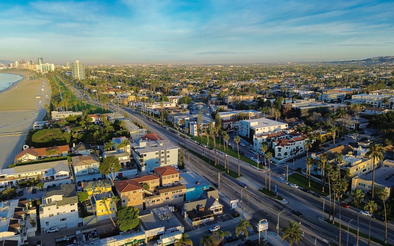 Aerial view of Belmont Heights, with the coastline and a main road running alongside homes and businesses.