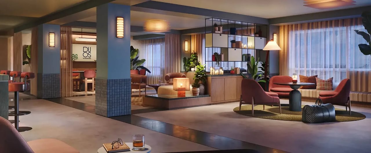 Duos Wynwood lounge with coral seating, a tiled bar, and a central fireplace.