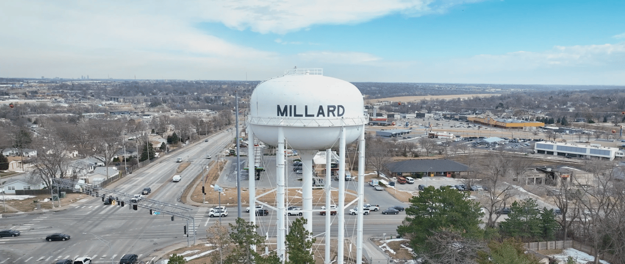 Millard water tower overlooks an intersection, homes, and businesses in Omaha.
