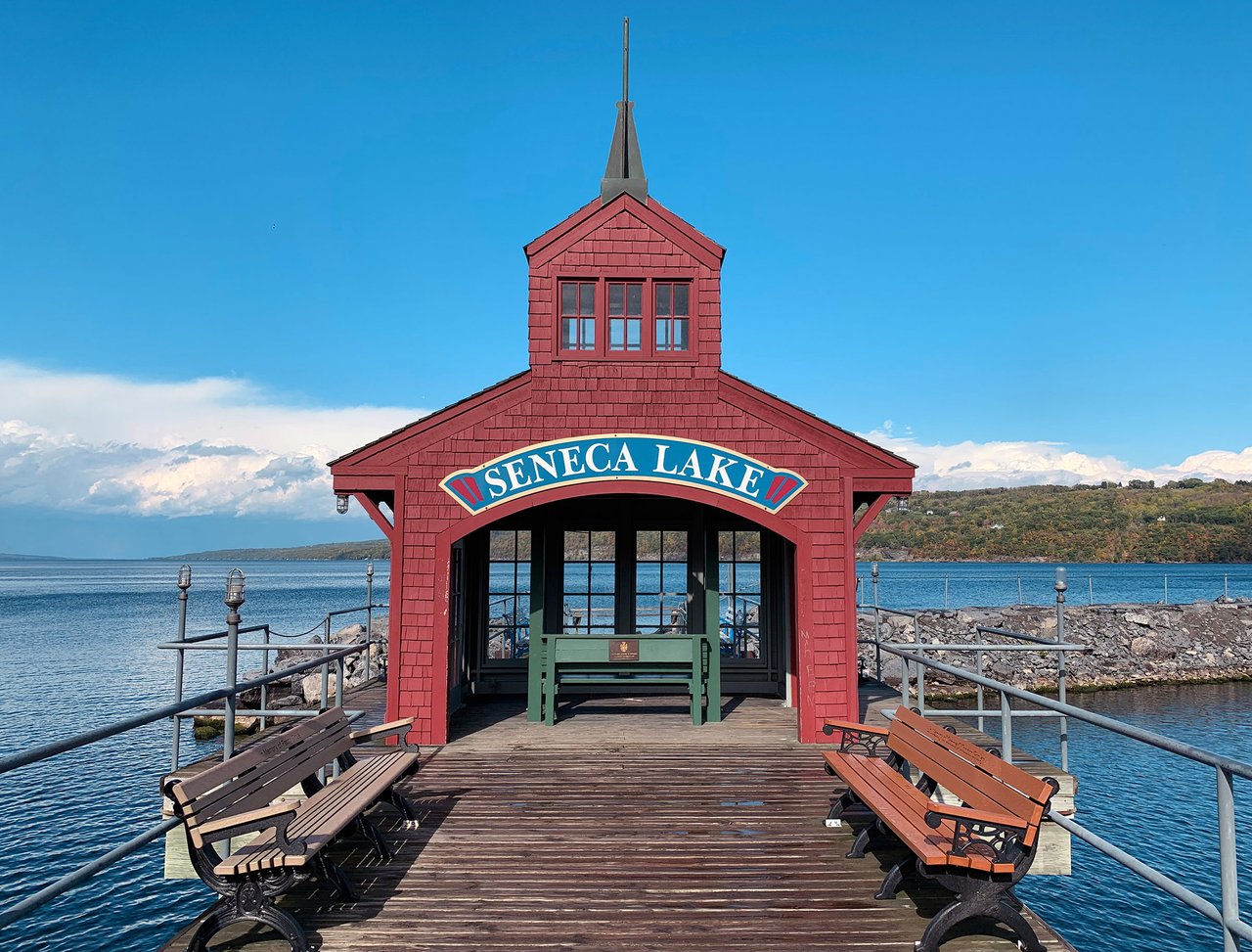 Seneca Lake pavilion at the end of a wooden pier, with benches overlooking the water.