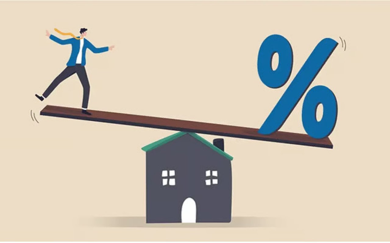 A person balances a large percent sign on a seesaw above a small house.