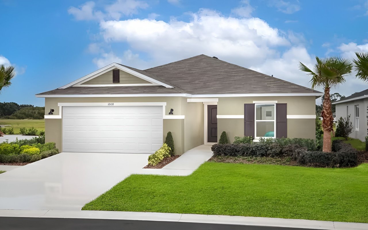 Single-story beige home with a white double garage door, palm tree, and broad green lawn.