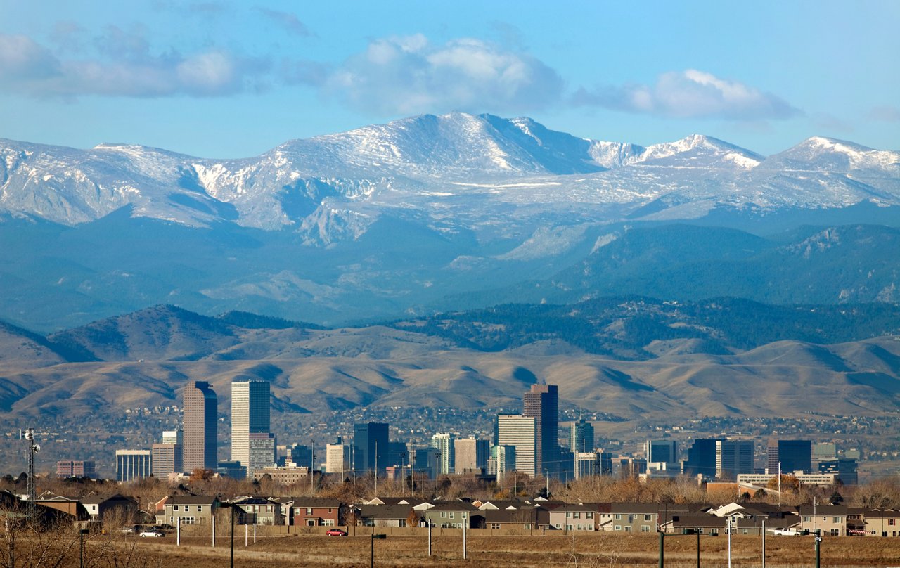 Denver skyline with the Rocky Mountains in the background representing the April 2026 real estate market update and stable housing trends.