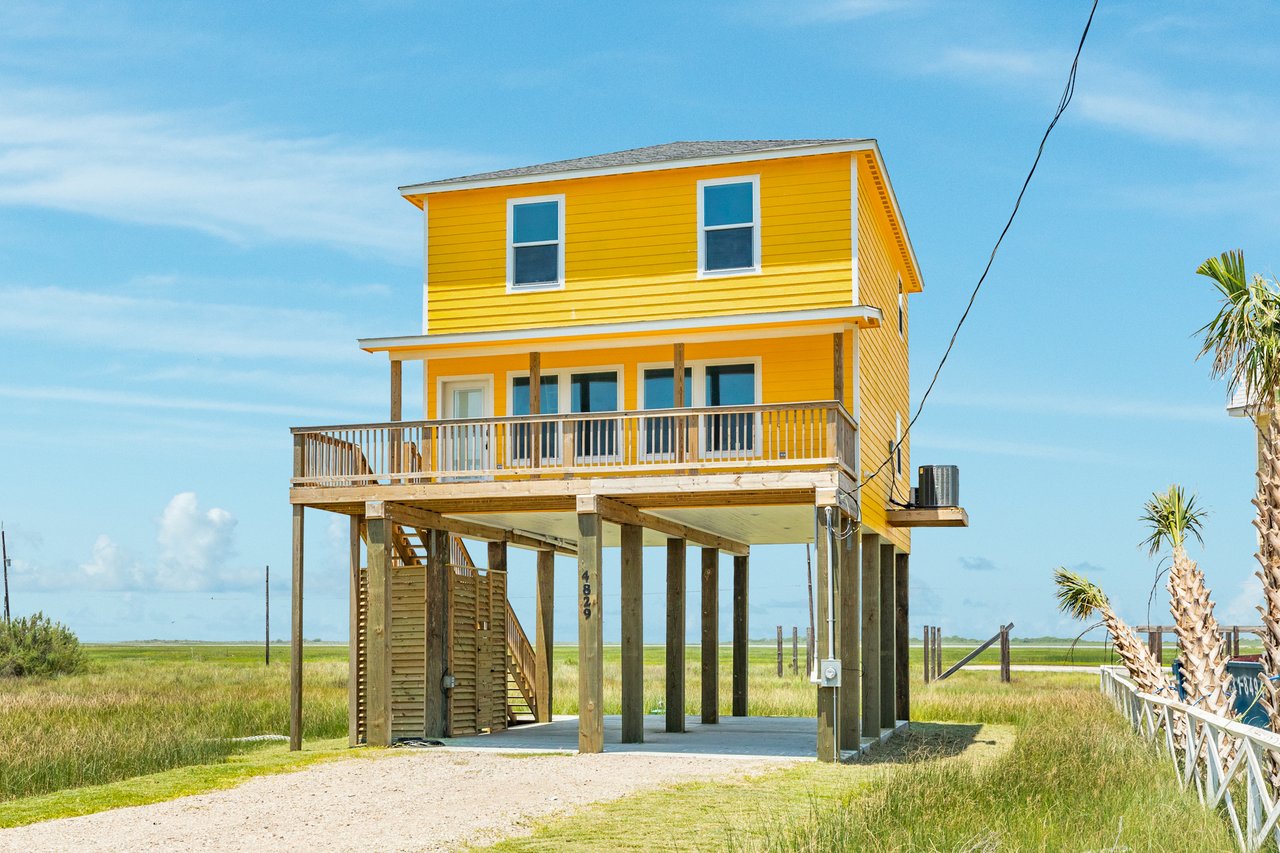 Bright Yellow Beach Home Exterior at 4829 Bluewater, Freeport Texas, presented by Carter Signature Properties. ort Texas