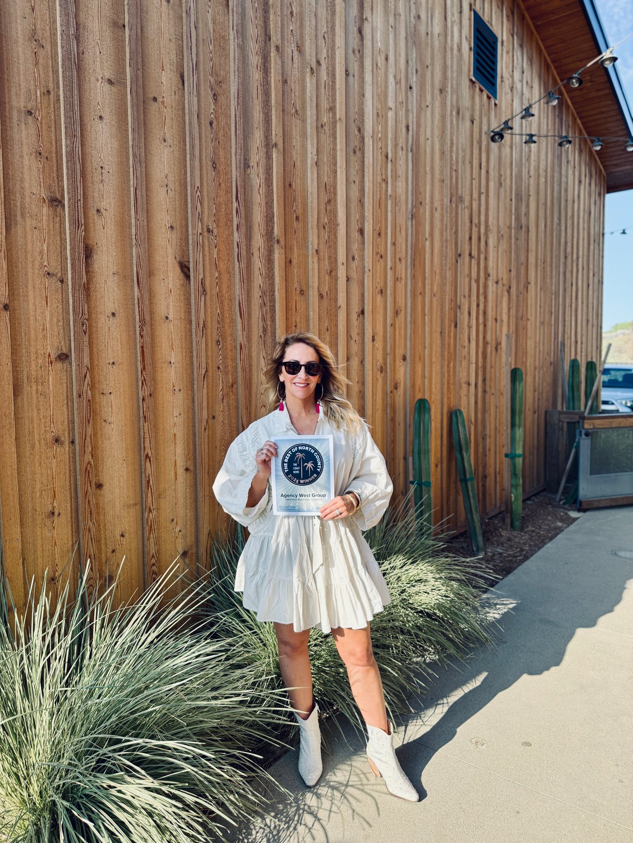 Amy Ali, founder of Agency West, holding the 2025 Best Real Estate Company award from The Coast News Best of North County in San Diego