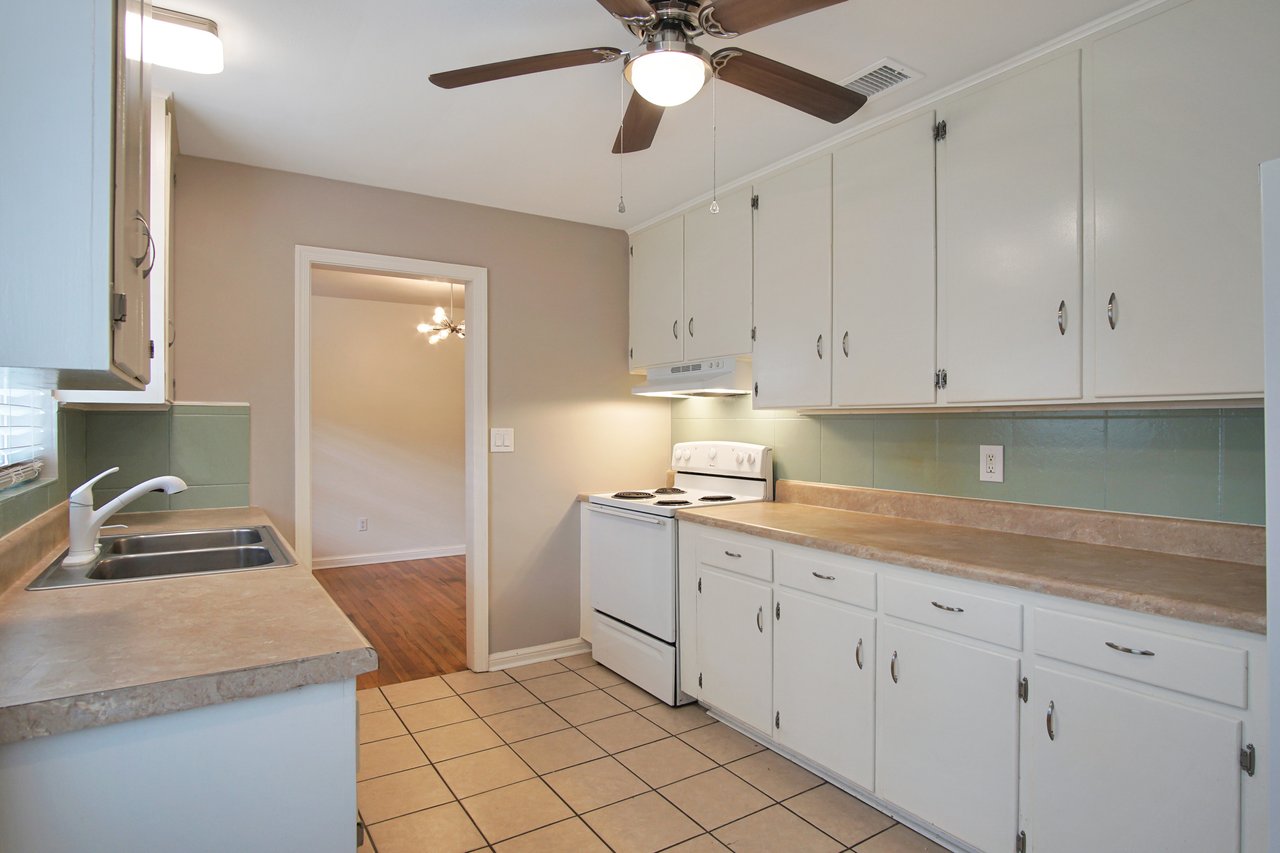 A kitchen featuring a ceiling fan above and a sink, showcasing a clean and functional cooking space.