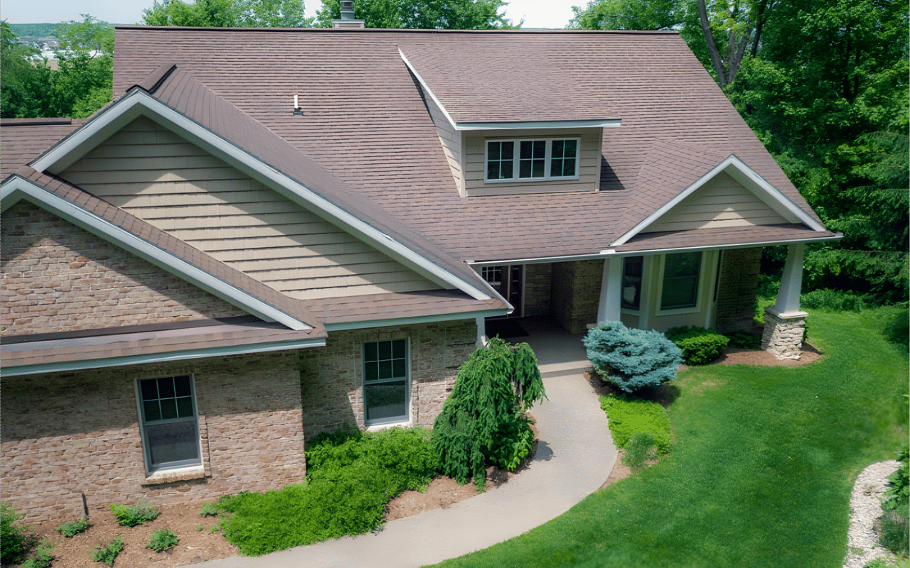House with a multi-gabled roof, stone facade, and landscaped front lawn.