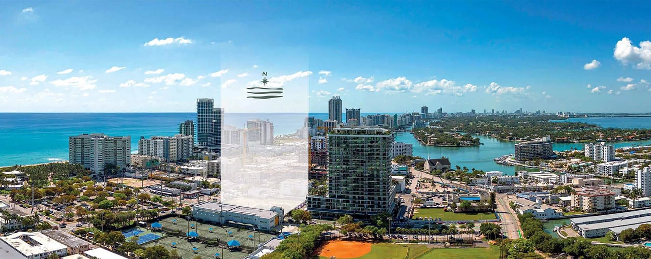 Aerial panorama of a coastal city with ocean, waterways, high-rise buildings, and a compass marker.