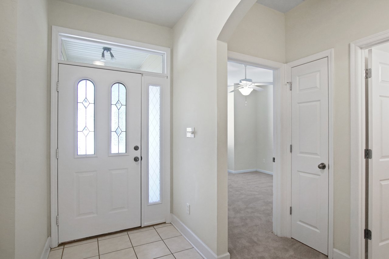 Entryway at 5441 Hampton Hill Circle, Tallahassee, Florida 32311 with decorative glass front door, arched opening, and tiled floor.