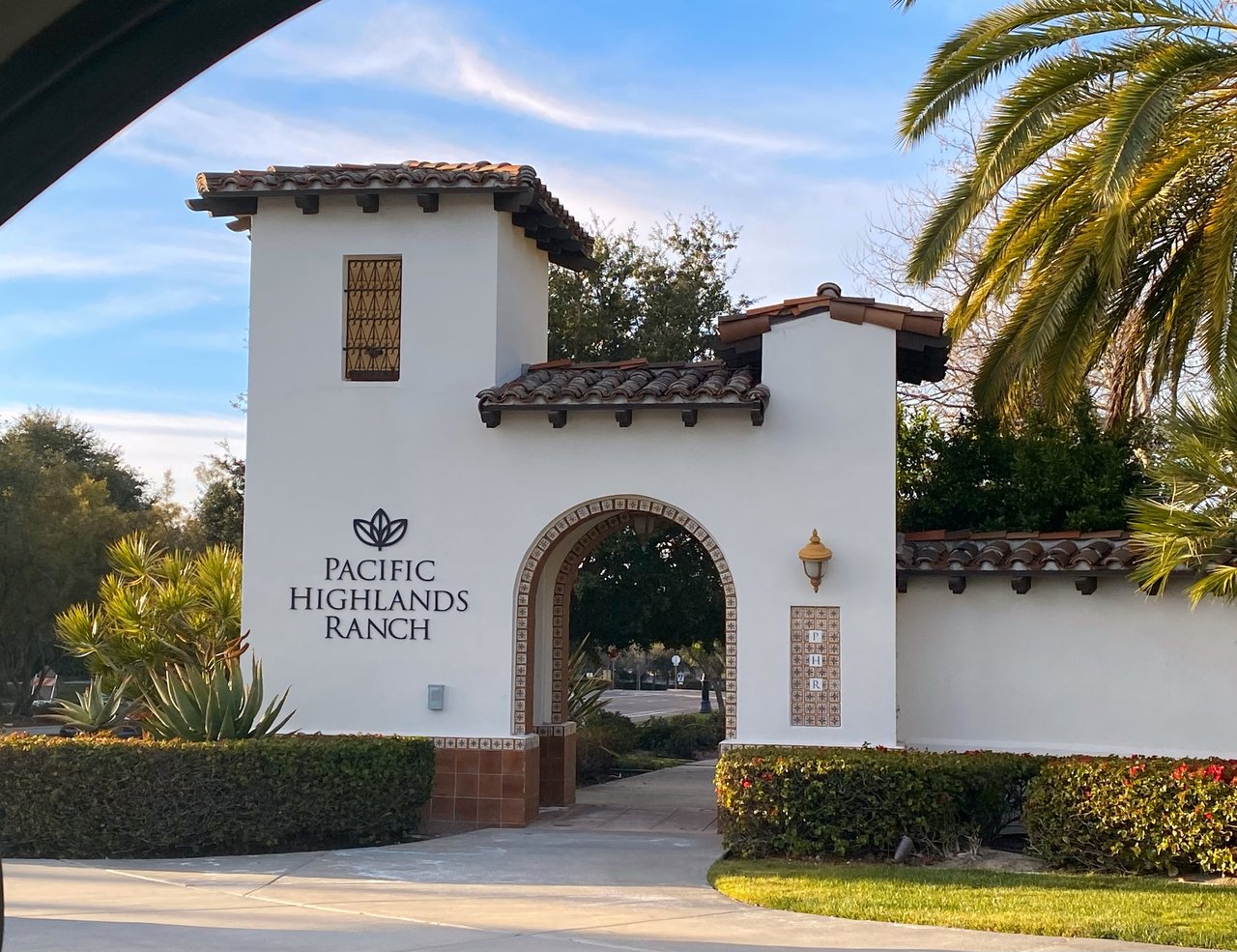 Spanish-style entrance to Pacific Highlands Ranch in Carmel Valley, San Diego, showcasing the gated community’s landmark archway and landscaping.