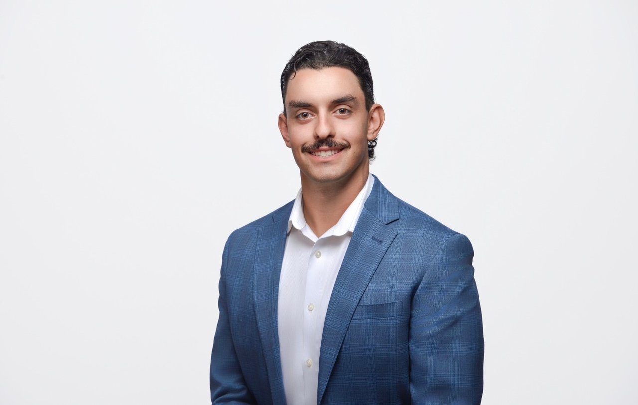 Noah Spagnuolo in a blue plaid suit jacket and white shirt.