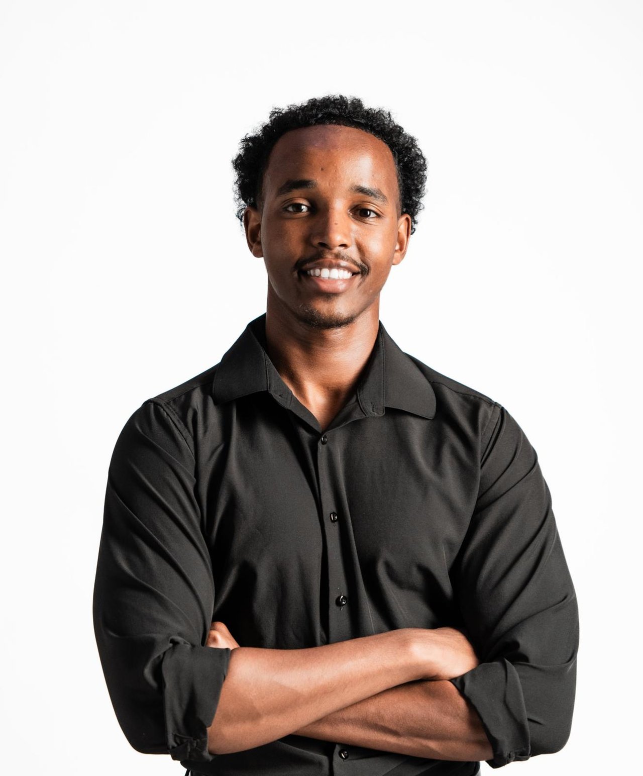 Ali Said, real estate agent, in a black shirt with his arms folded.