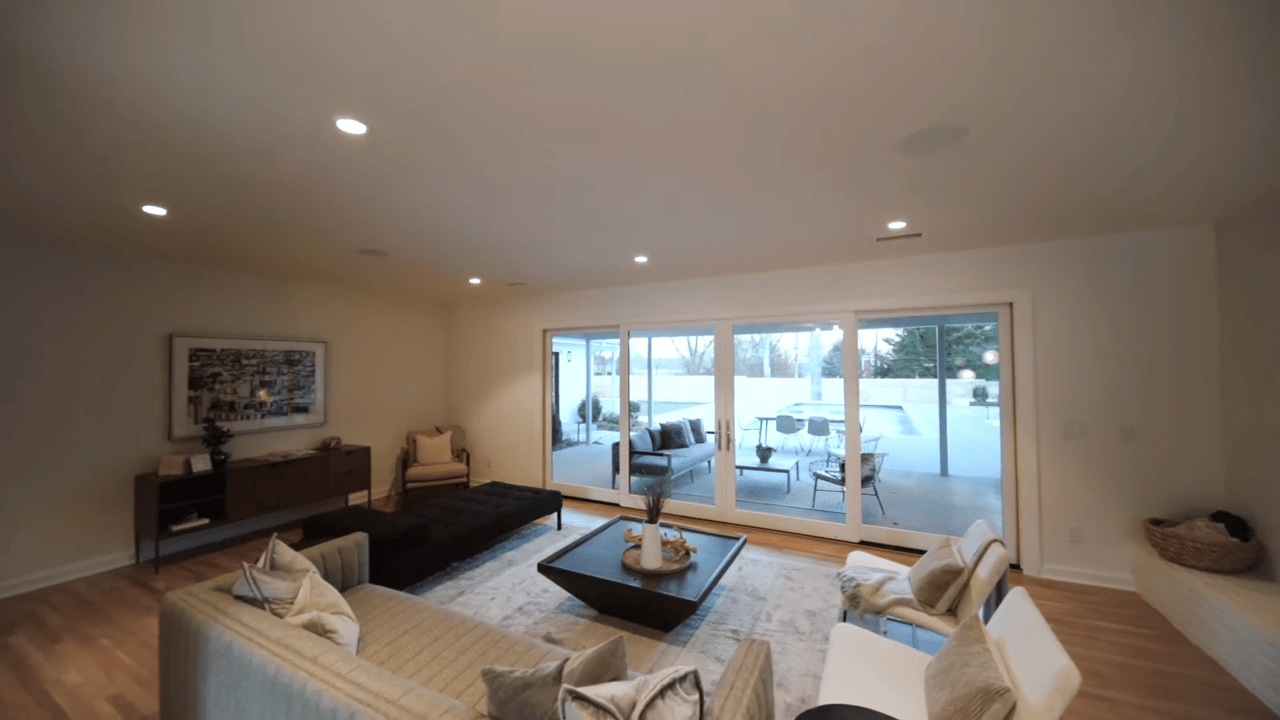 Living room with a dark coffee table and sliding doors overlooking a pool patio.