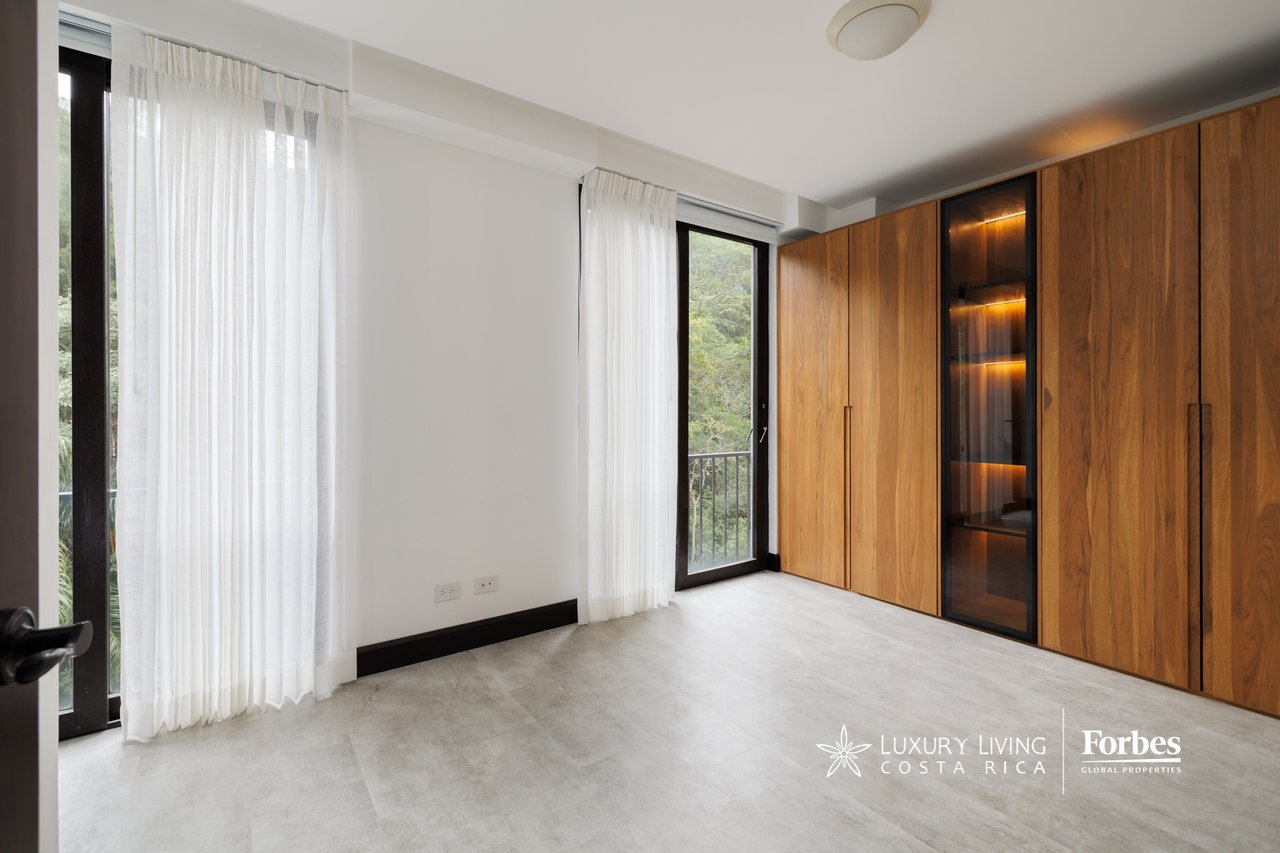 Unfurnished room with floor-to-ceiling wood wardrobes and glass balcony doors.