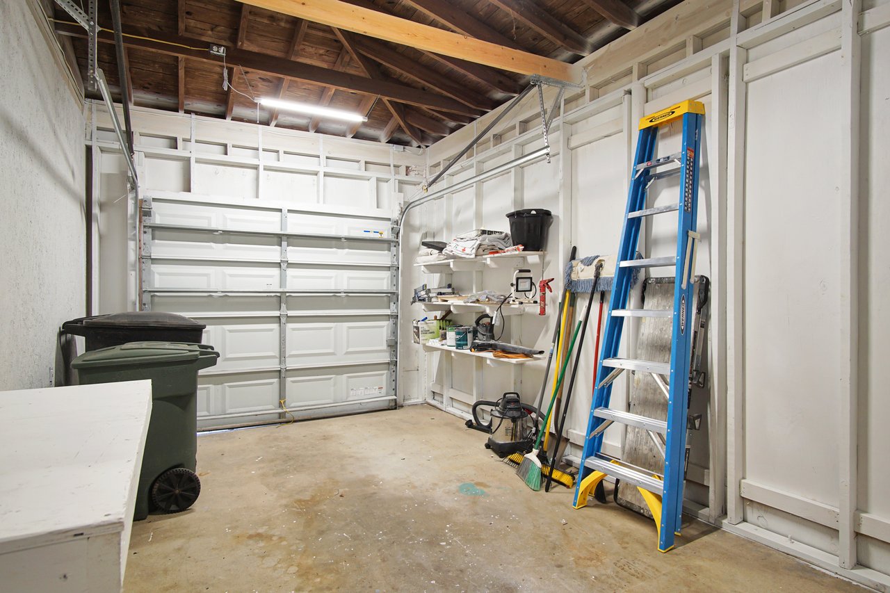 A garage room featuring a ladder and a toolbox, organized for efficient storage and easy access to tools.