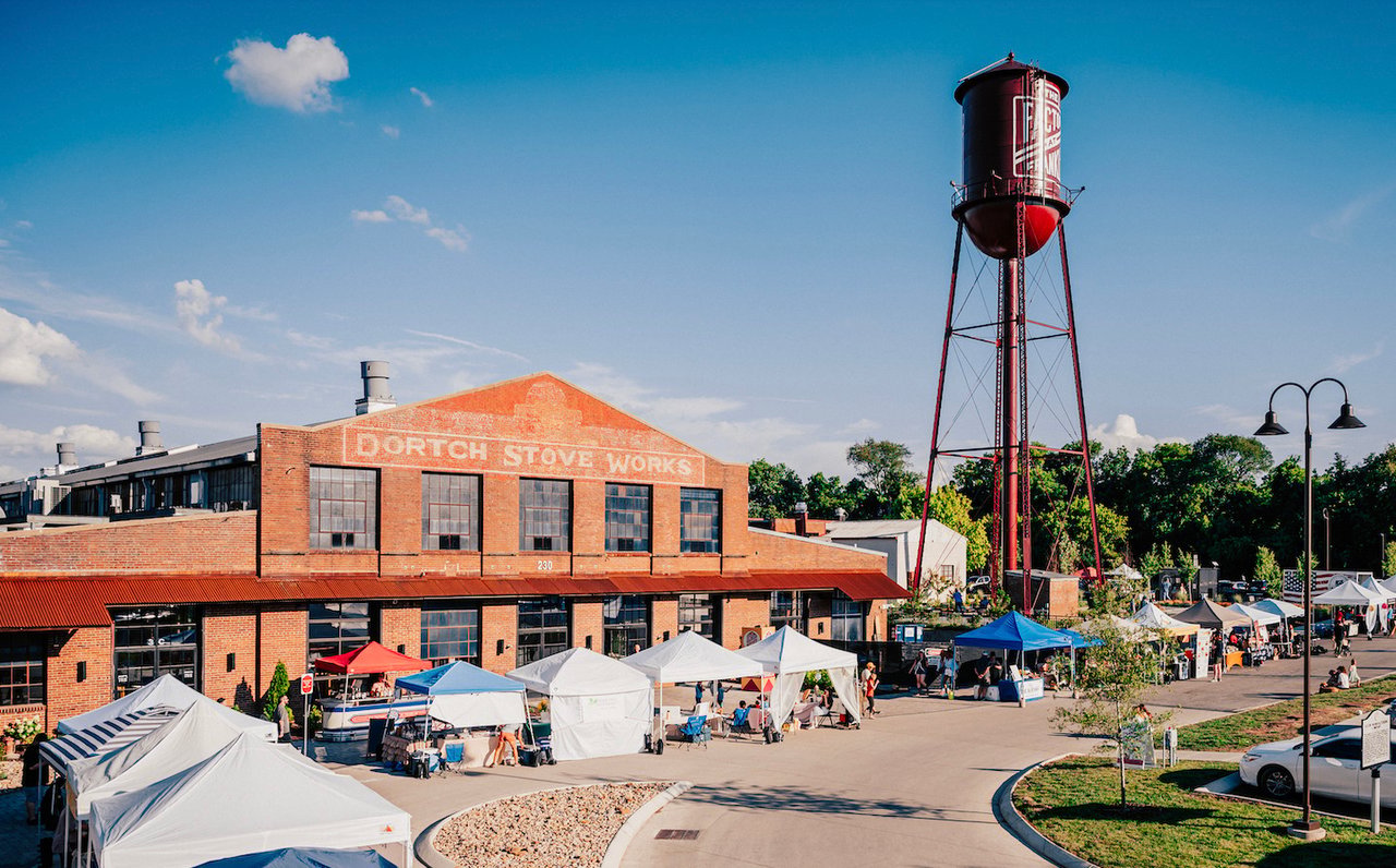 Fortch Stove Works brick building and water tower overlooking an outdoor market.