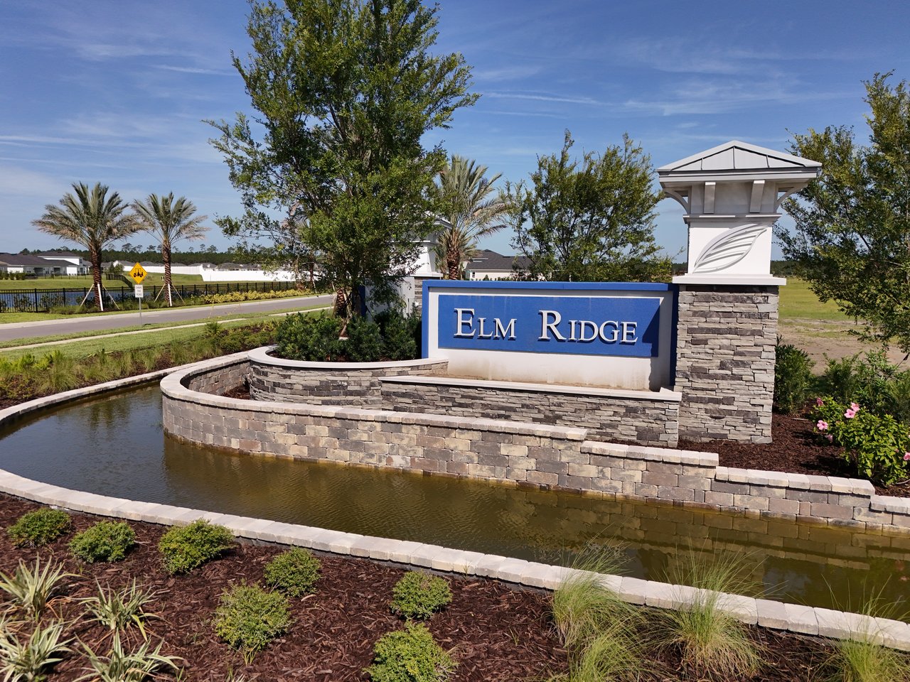 Elm Ridge entrance sign beside a landscaped water feature.