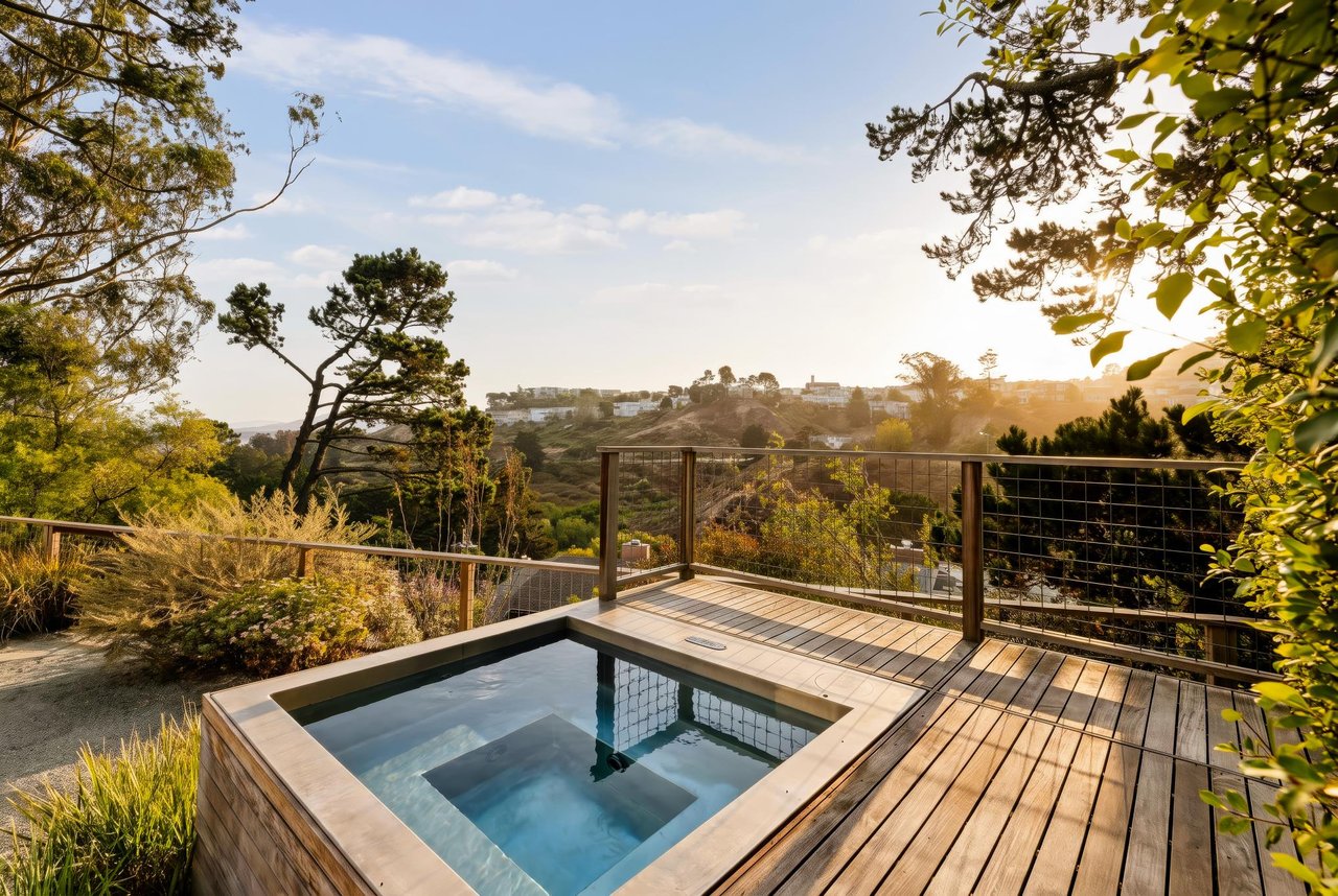 Outdoor pool and wooden deck overlooking a tree-covered hillside.