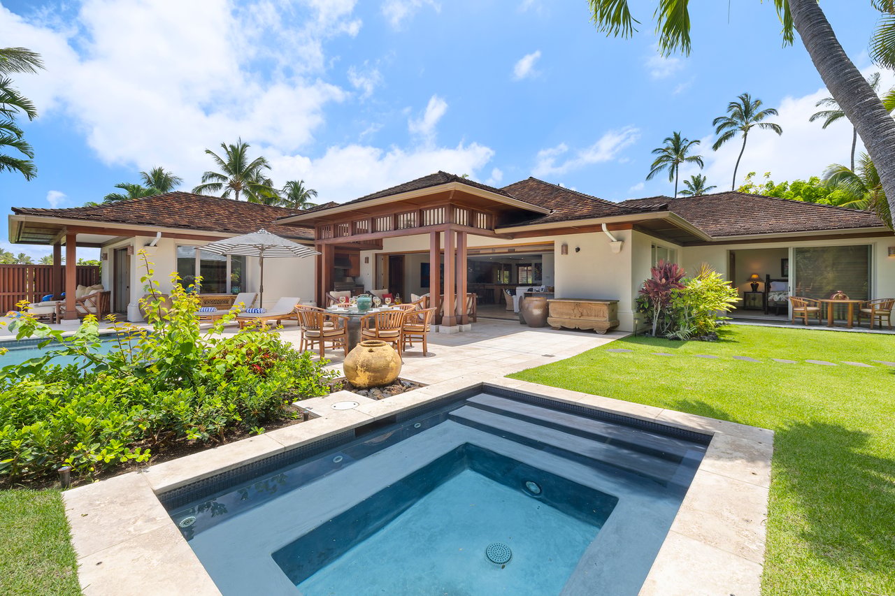 Tropical home with a swimming pool, covered lanai, and furnished patio.