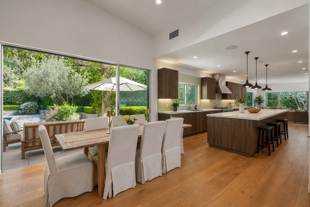 Open-plan kitchen and dining area with a large island and glass doors to a landscaped patio.