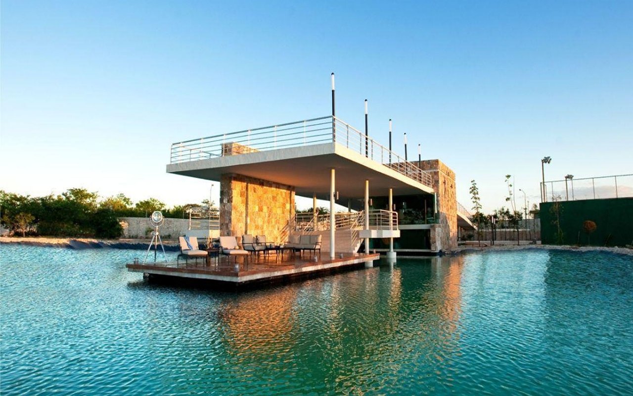 Poolside clubhouse pavilion over a turquoise community pool with a furnished deck.