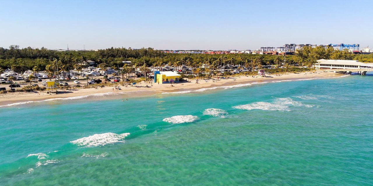 Aerial view of Dania Beach, Florida with turquoise water, sandy shoreline, and Dania Beach Pier.