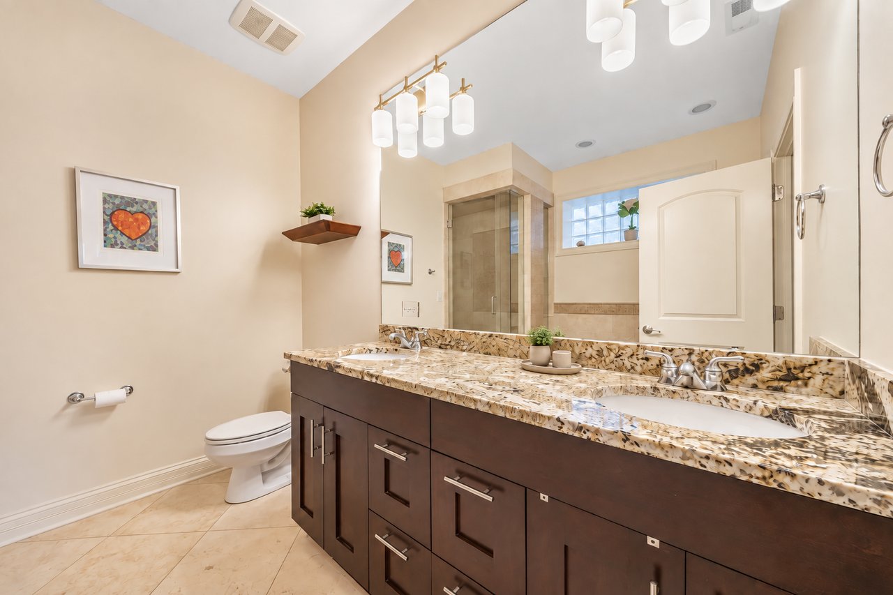Primary bathroom with double vanity and granite counters