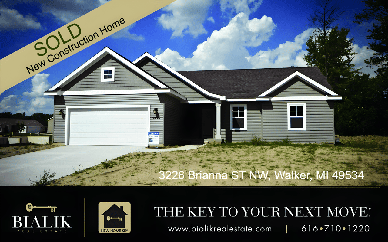 Newly built gray-green home with white trim and a two-car garage, marked sold.