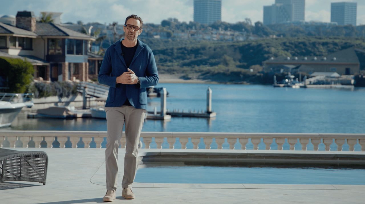 Tim Smith standing by a pool next to the harbor offering a neighborhood tour of Dover Shore, Westcliffe, Newport Beach