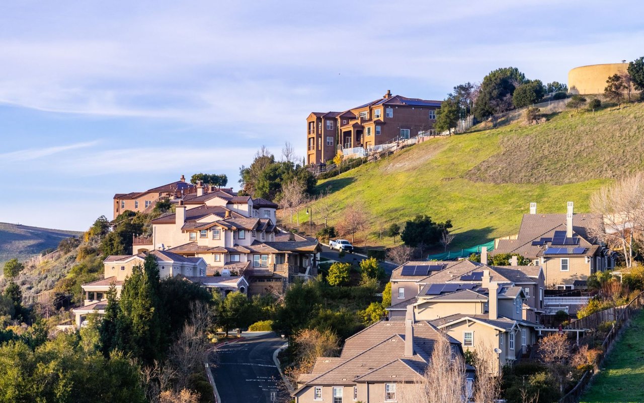 Hillside neighborhood in Hayward with homes, a winding road, and solar panels.