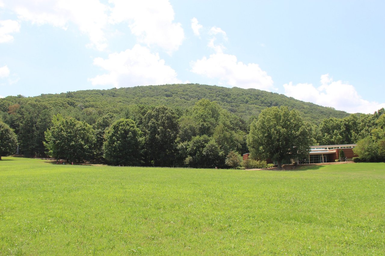 Kennesaw Mountain rising above a wide green field and tree line at the national battlefield park in Cobb County, GA