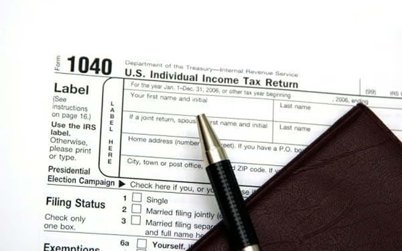 Form 1040 tax return with a pen and brown leather wallet.