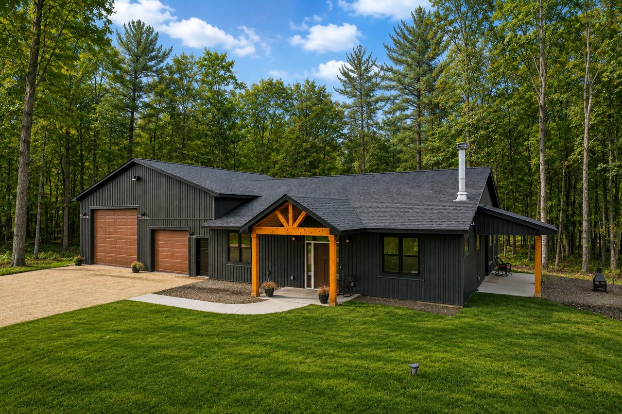 Dark modern home with a timber-framed porch and attached garage, surrounded by trees.