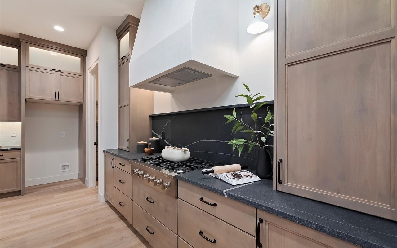 Kitchen with black leathered granite counters and Venetian plaster range hood.
