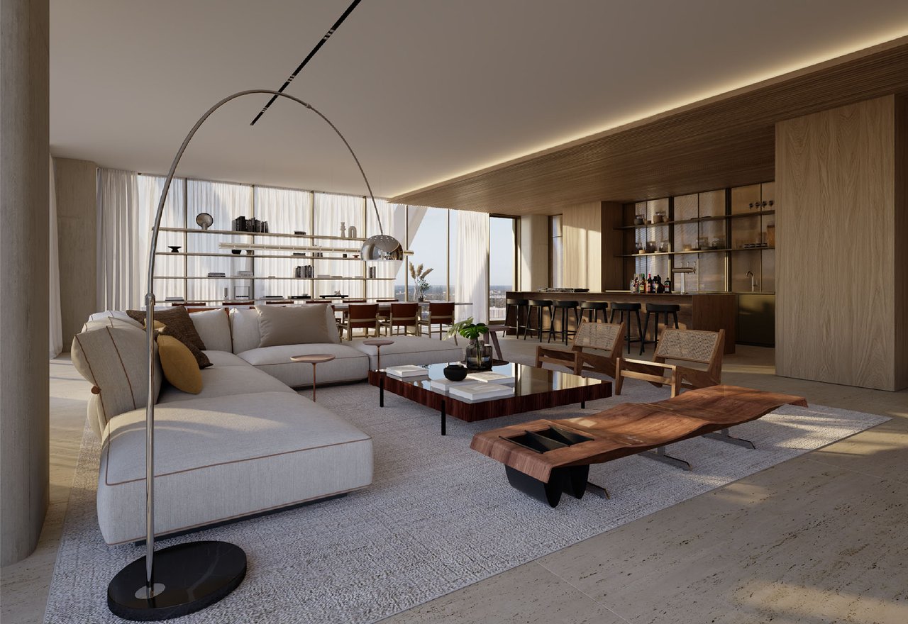 Luxury condo living room with a sculptural wood coffee table and open kitchen.