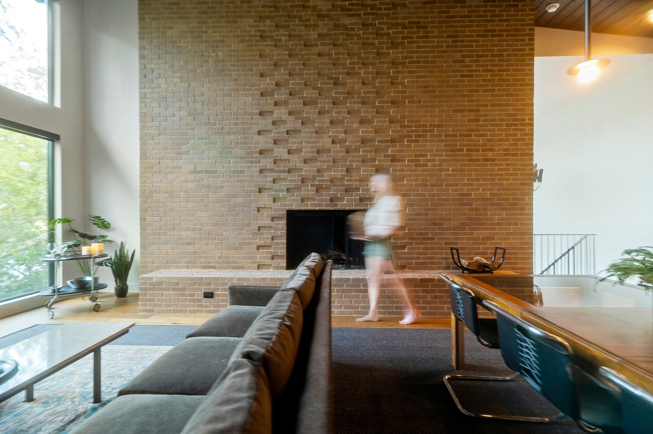 Floor-to-ceiling textured brick fireplace with a wall-to-wall brick bench, designed by Kelley Design Group and built by Pecan Valley Custom Homes. Lake Austin waterfront at 2403 Big Horn Drive, Austin.