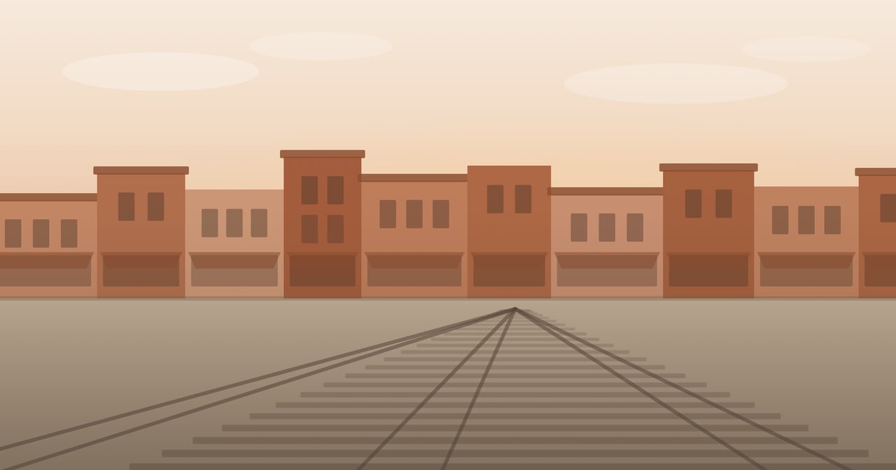 Brick storefronts along the railroad tracks of a small Alabama downtown at golden hour