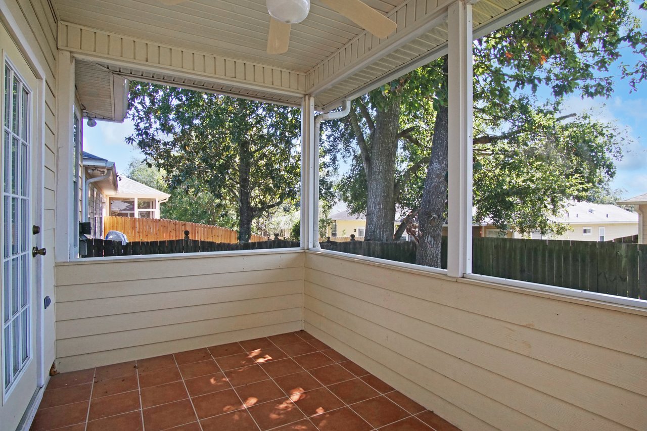 Screened porch at 5441 Hampton Hill Circle, Tallahassee, Florida 32311 with tile flooring, ceiling fan, and fenced backyard view.