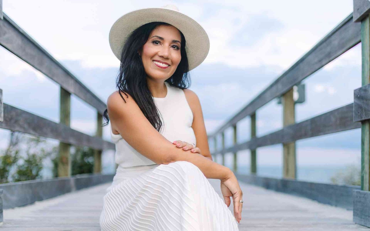 Michelle Almeyda Wiedemuth, Charleston real estate agent, smiling on a boardwalk by the coast