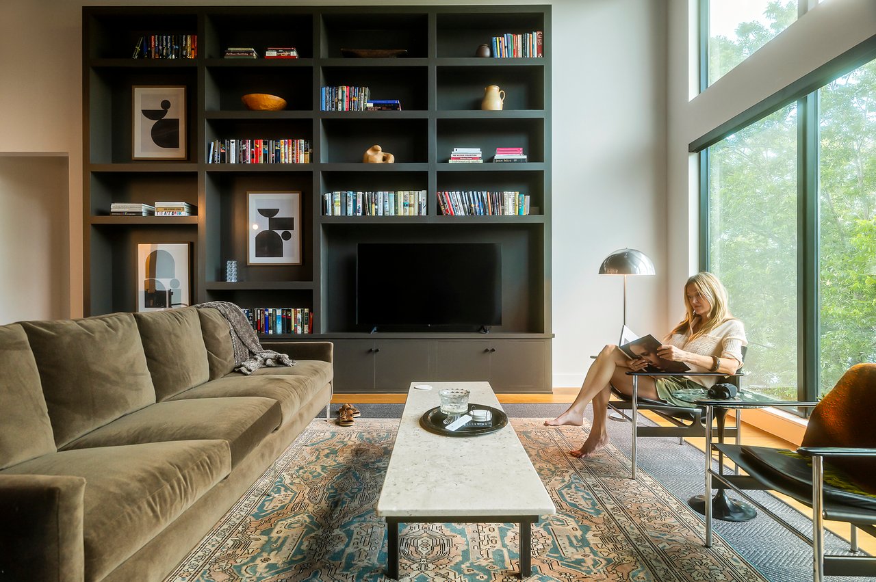 Living room with built-in bookshelves styled with art and books, furnished by Liz MacPhail Interiors. Lake Austin waterfront at 2403 Big Horn Drive, Austin.