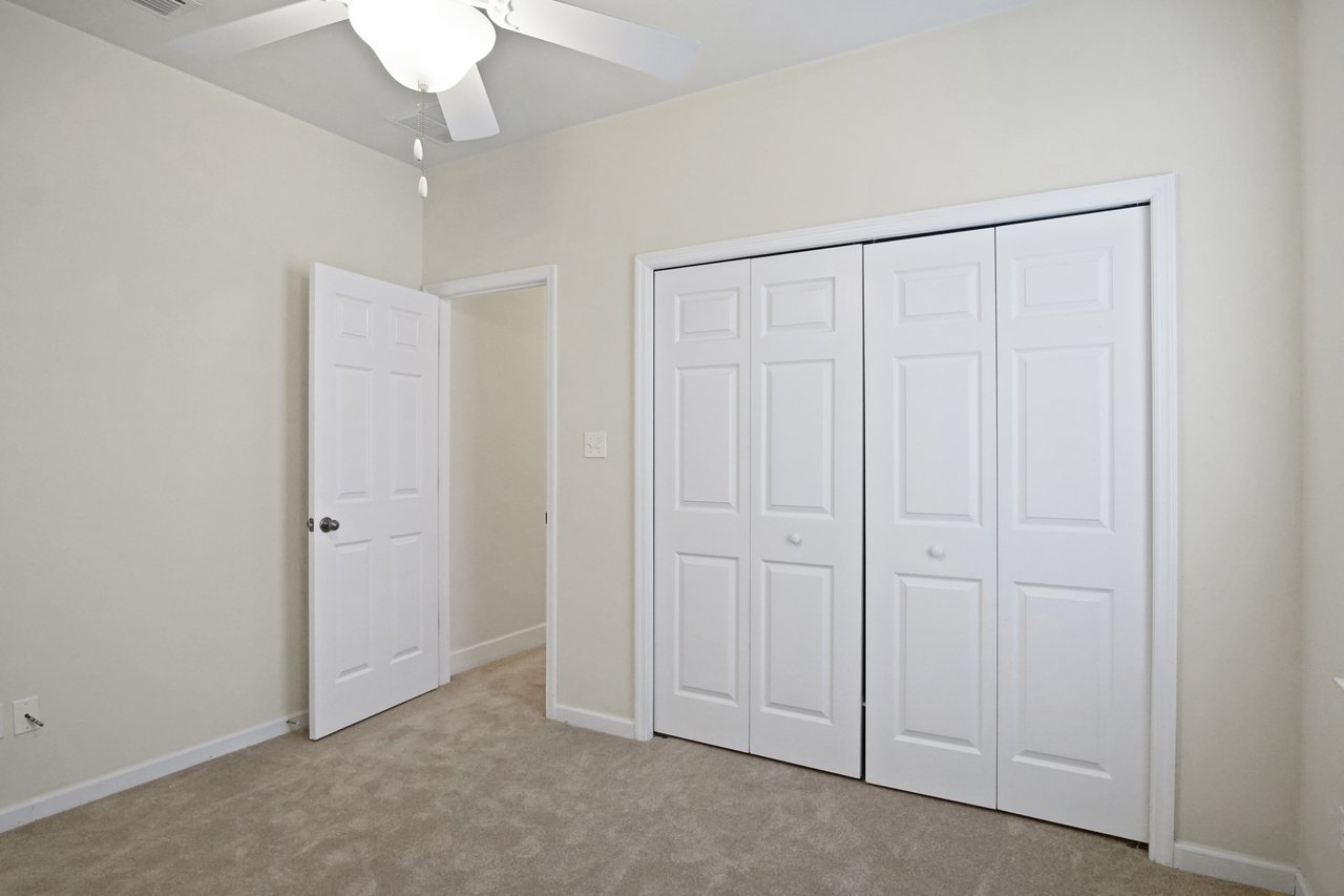 Bedroom at 5441 Hampton Hill Circle, Tallahassee, Florida 32311 featuring ceiling fan, double closet doors, and carpet flooring.