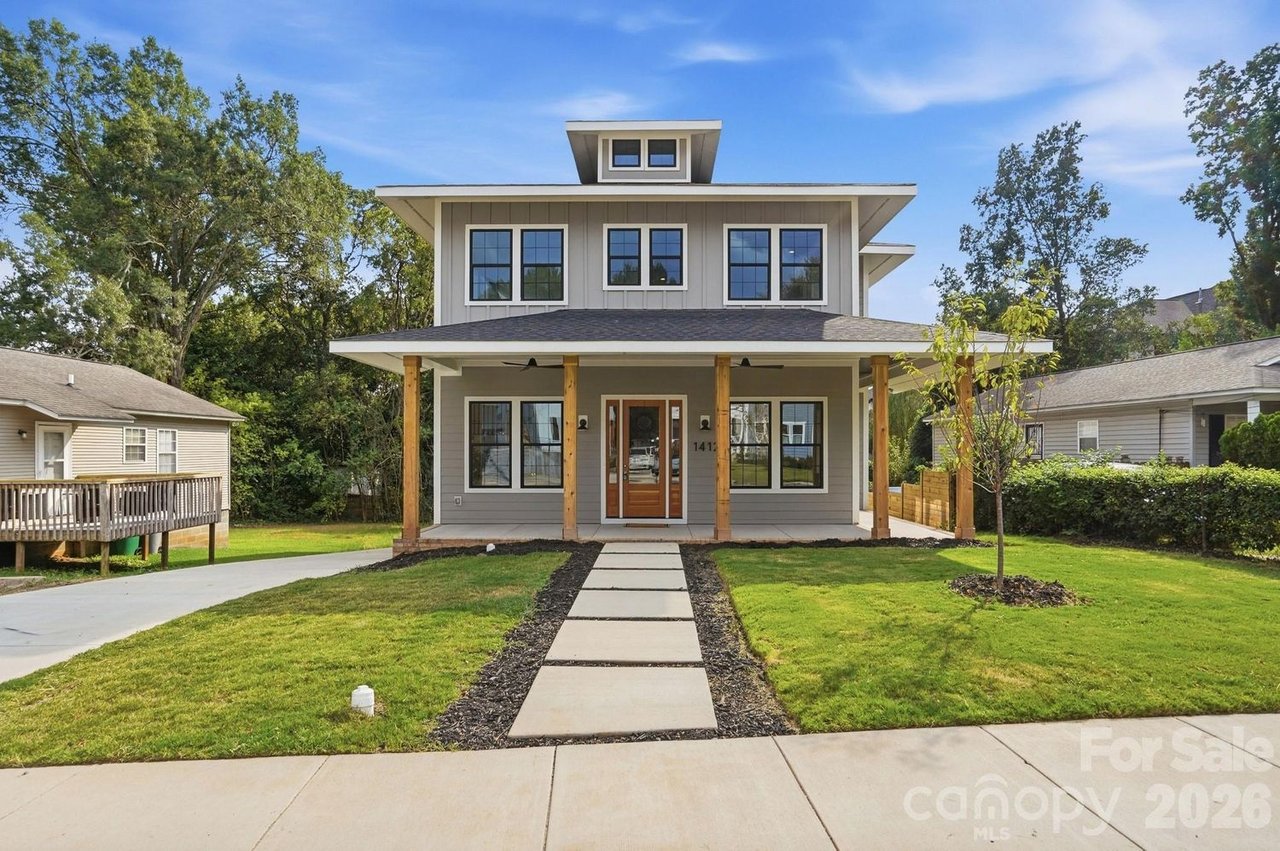 Modern gray two-story home with a covered porch, front walkway, and landscaped lawn.