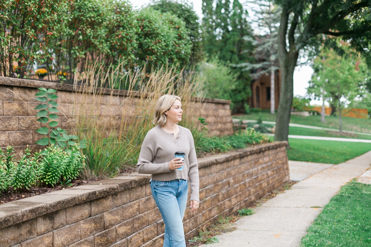Cait Berry of Insiders Realty walking through a Madison, Wisconsin neighborhood while discussing how much a home is worth and factors impacting local property prices.