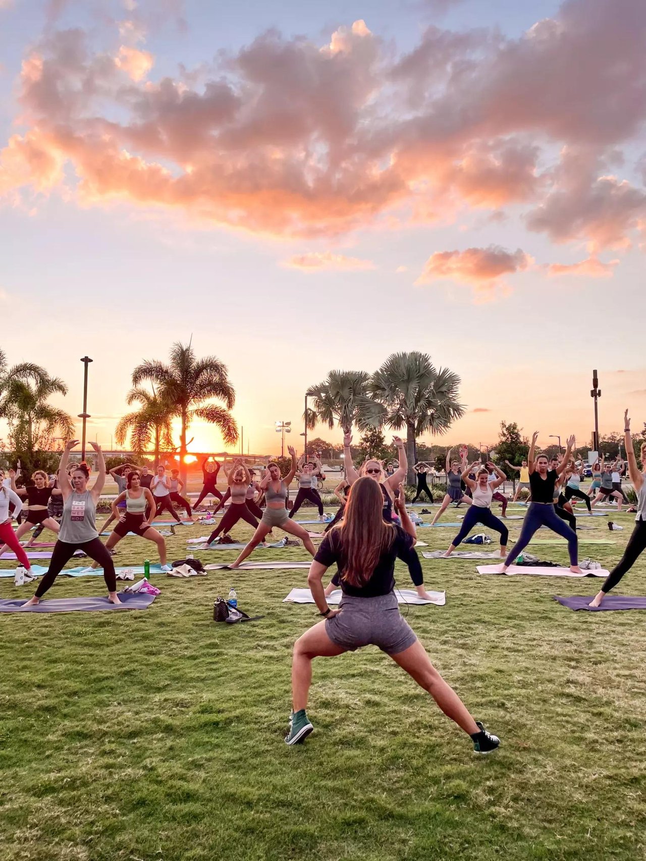 Participants attending an outdoor group yoga class at Armature Works in Tampa, Florida.