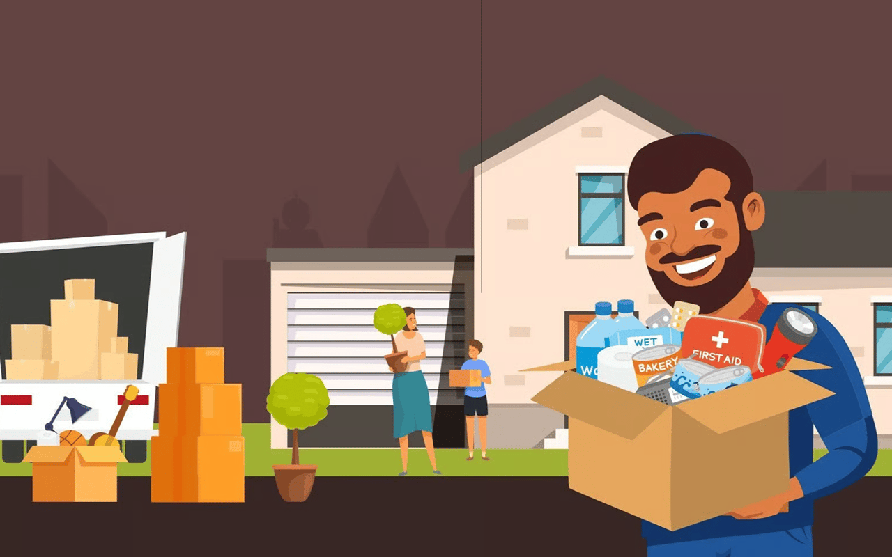 Smiling mover holds a box of household supplies as a family unloads belongings outside a house.