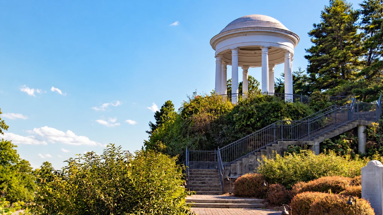 White domed pavilion with classical columns above stone steps and landscaped gardens in Vestavia Hills.