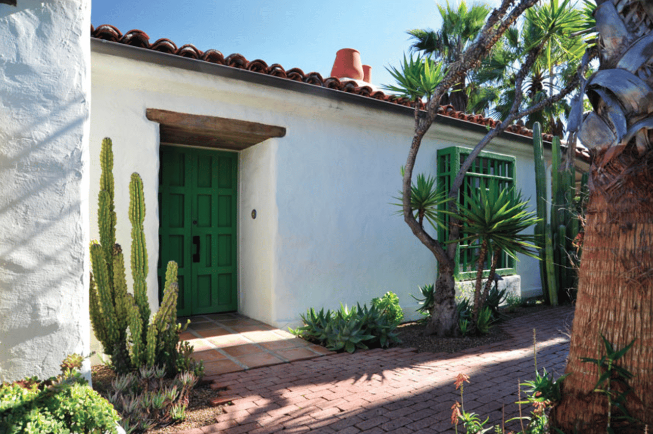 Low-slung California ranch house with a wide covered porch and courtyard, in the style Cliff May originated in San Diego in 1932