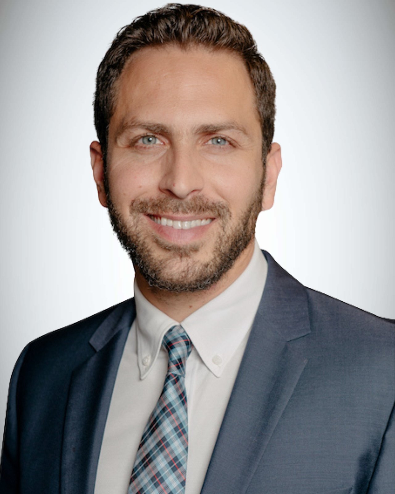 Mathew Pottens in a dark blue suit and patterned tie