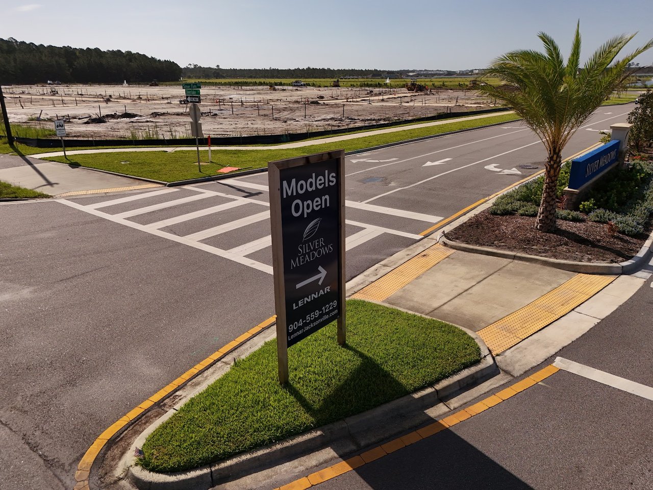 Silver Meadows entrance with a Models Open sign beside a new-home construction site.