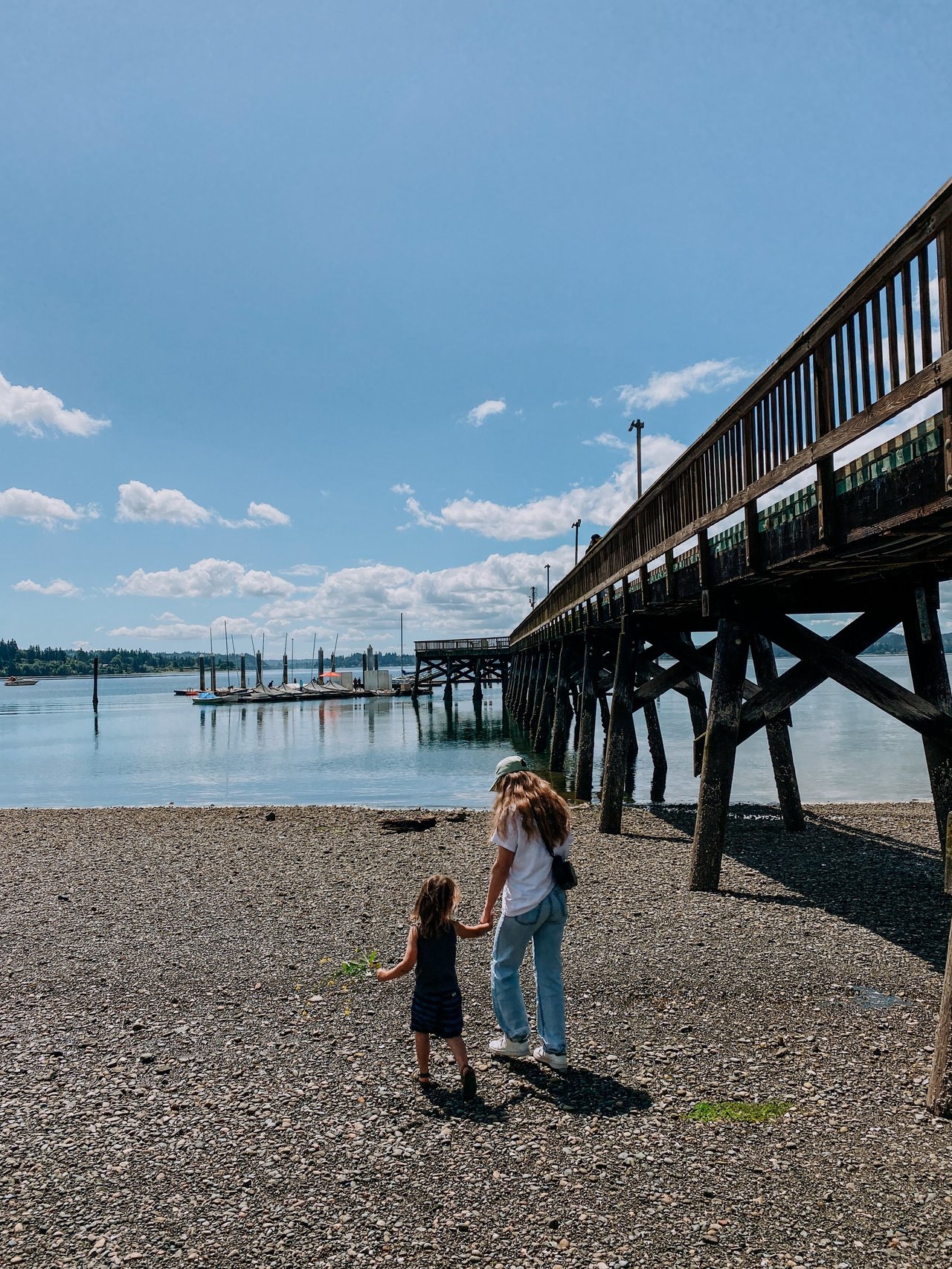 mother and daughter walking on beach in silverdale